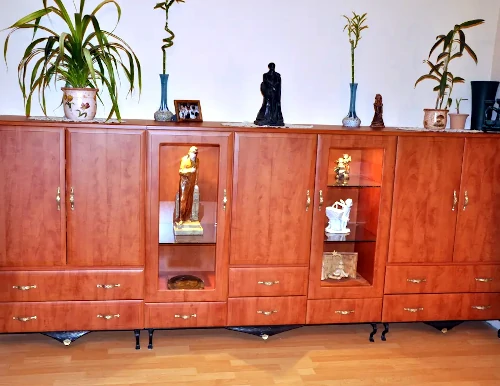 A képen egy igényes, fából készült, régi stílusú szekrény látható fiókos, szekrényes és vitrines résszel.